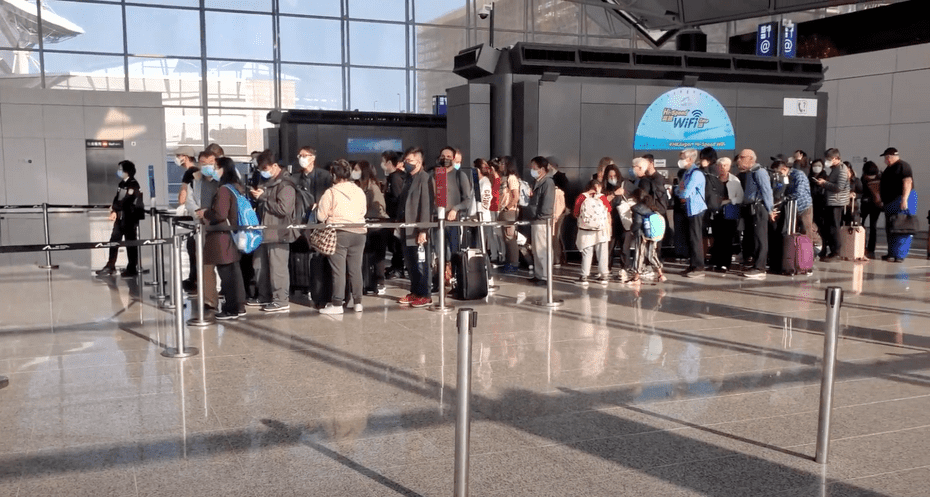 photo of people lining up at boarding gate at hong kong international airport